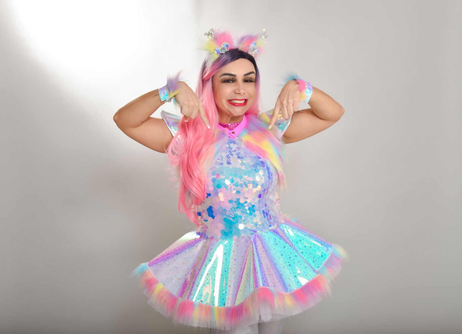 Tina Show com figurino de unicórnio, sorrindo e com os braços para cima
